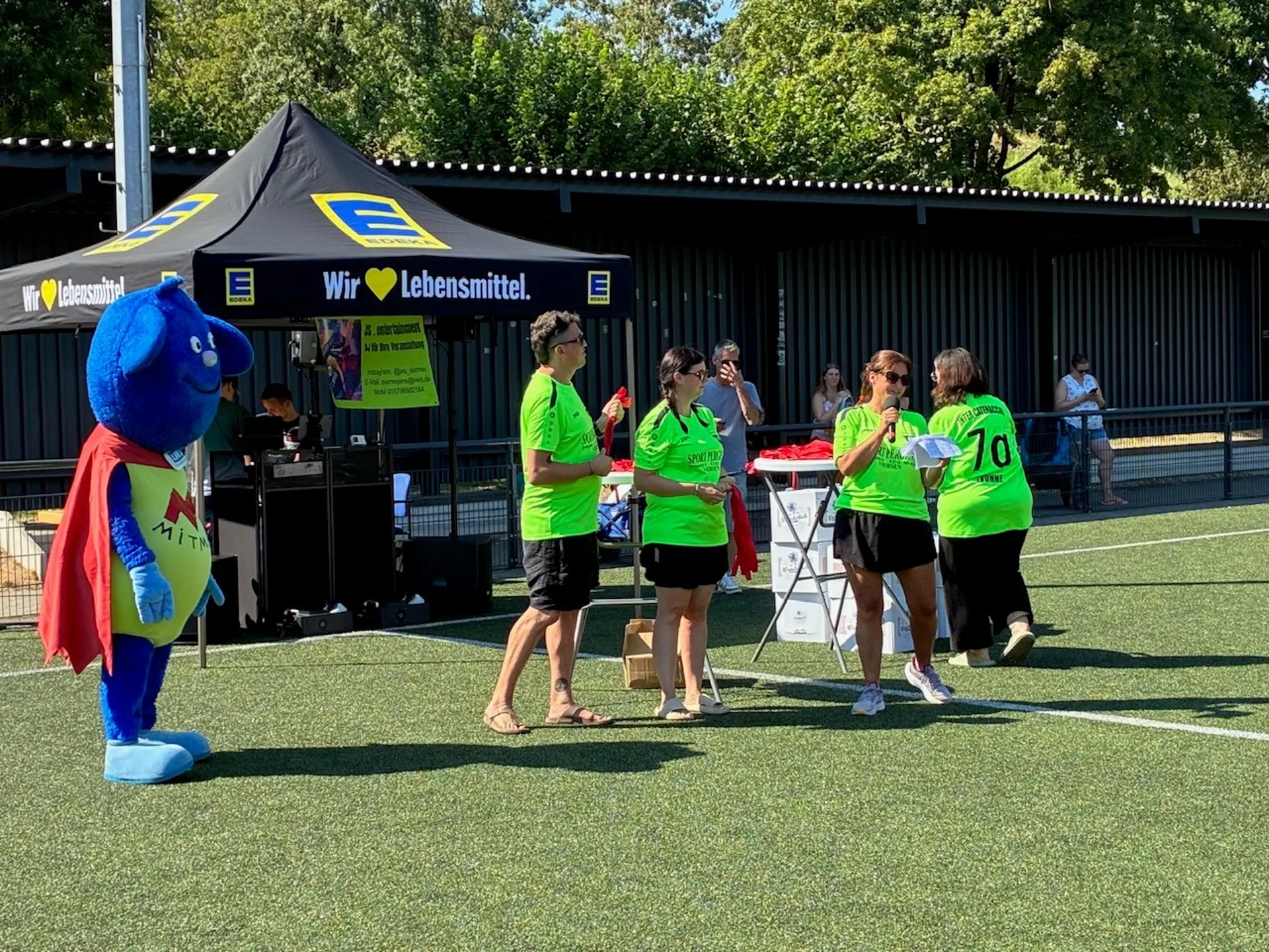 Moderator*innen auf dem Spielfeld.