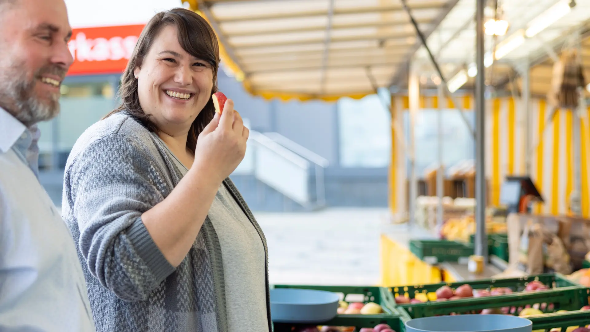 Ein Mann und eine Frau stehen an einem Marktstand.