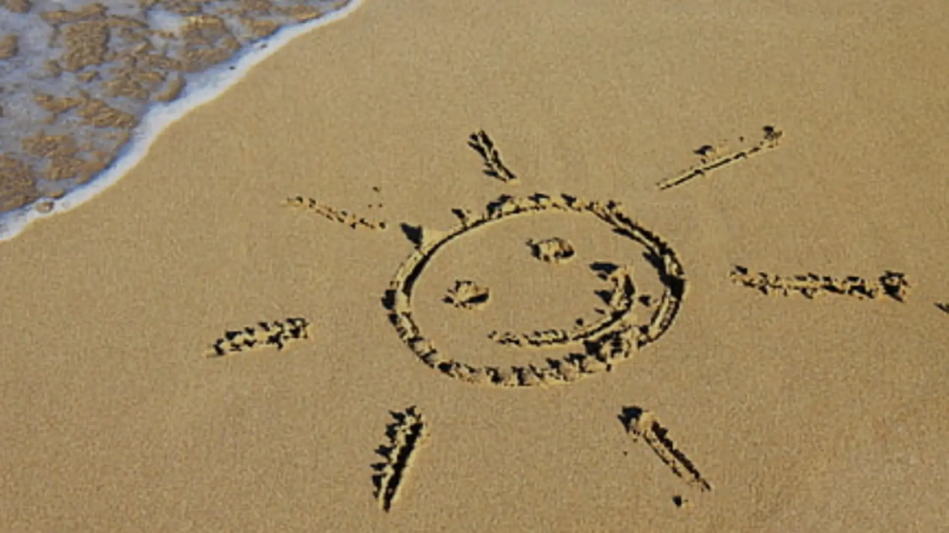 Sand am Strand, darin ist eine Sonne gekritzelt