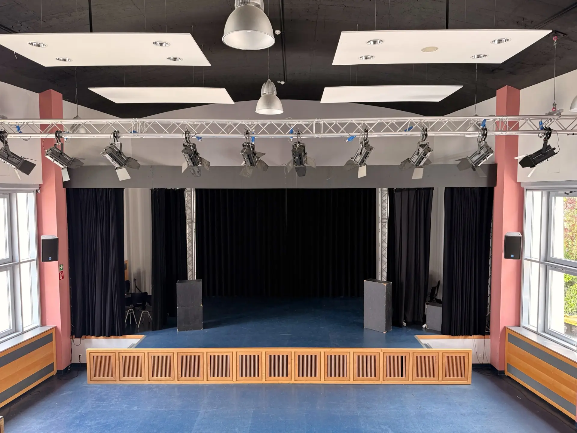 Die leere Bühne in der Aula der WKS mit professionellen Scheinwerfern und Verdunkelungsvorhängen an den Seiten.