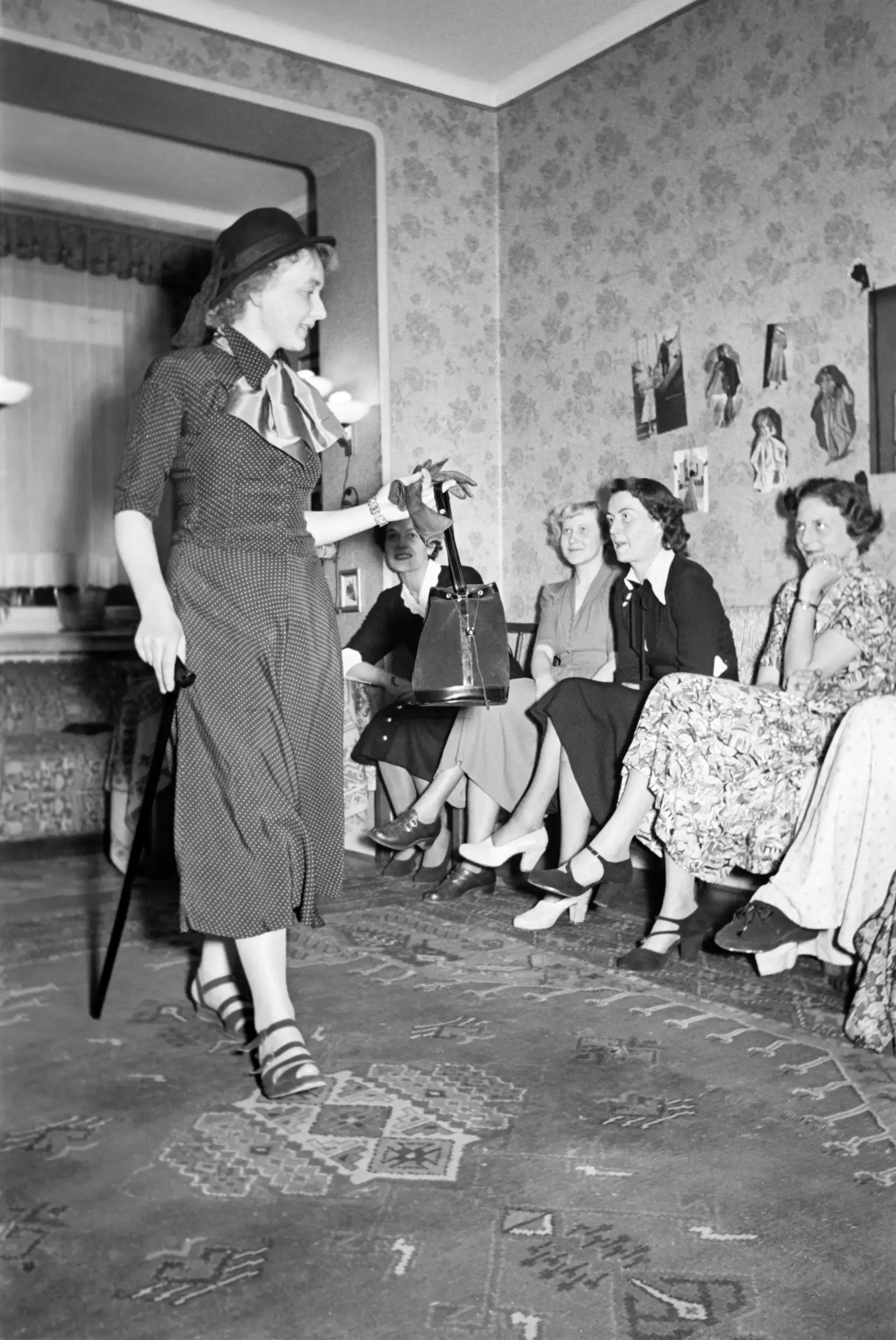 Eine Frau läuft an sitzenden Frauen vorbei.