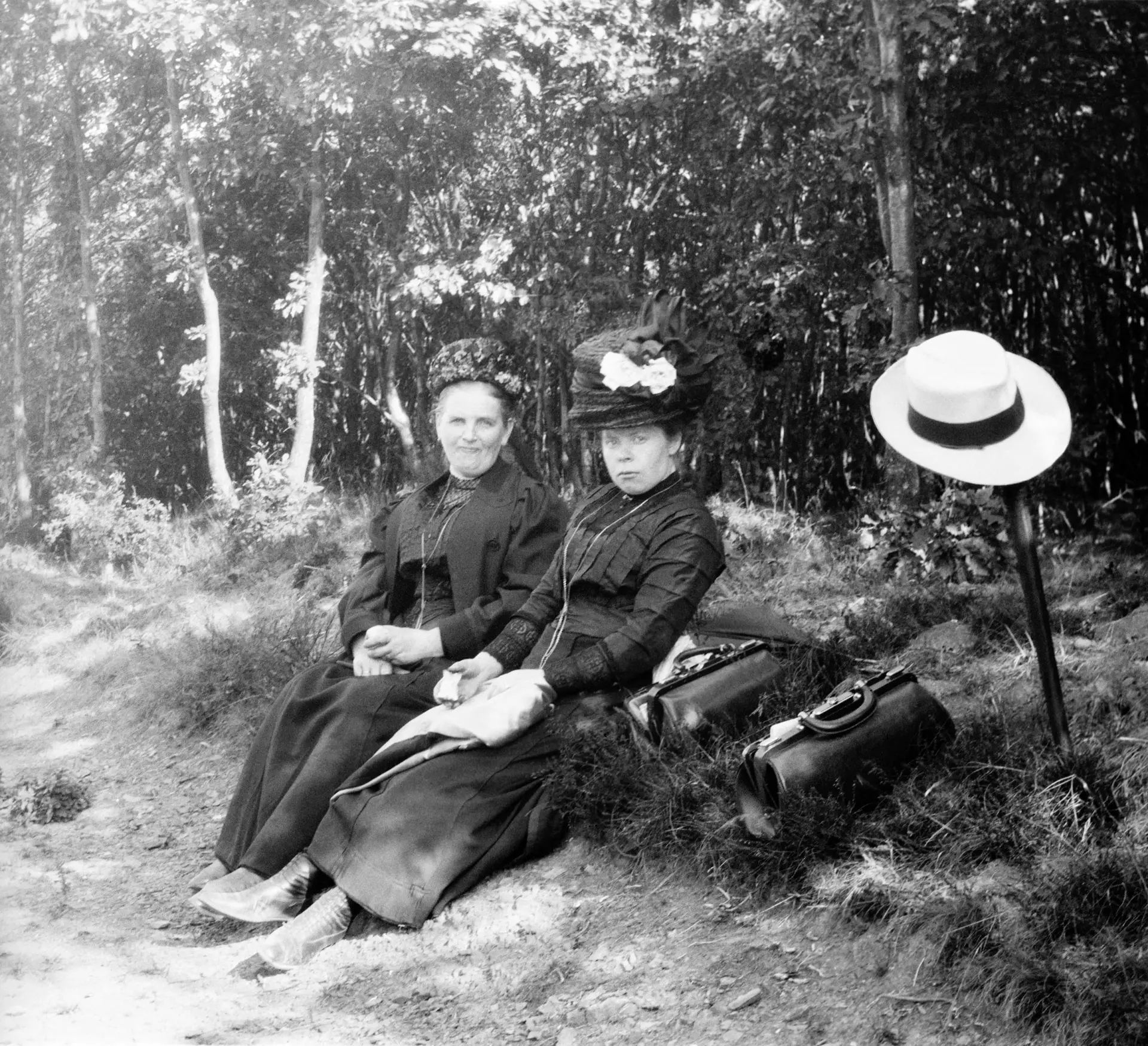 Zwei Frauen sitzen am Wegesrand.