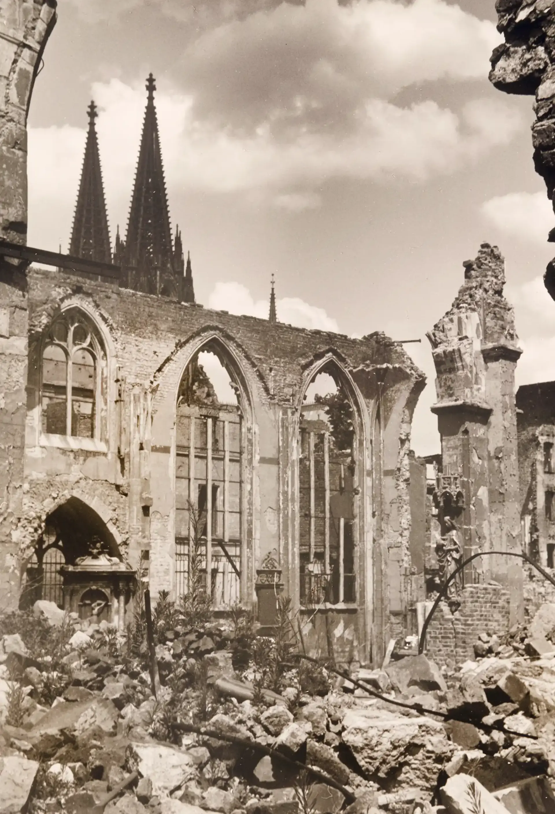 Ruine einer Kirche mit Kirchtürmen im Hintergrund.