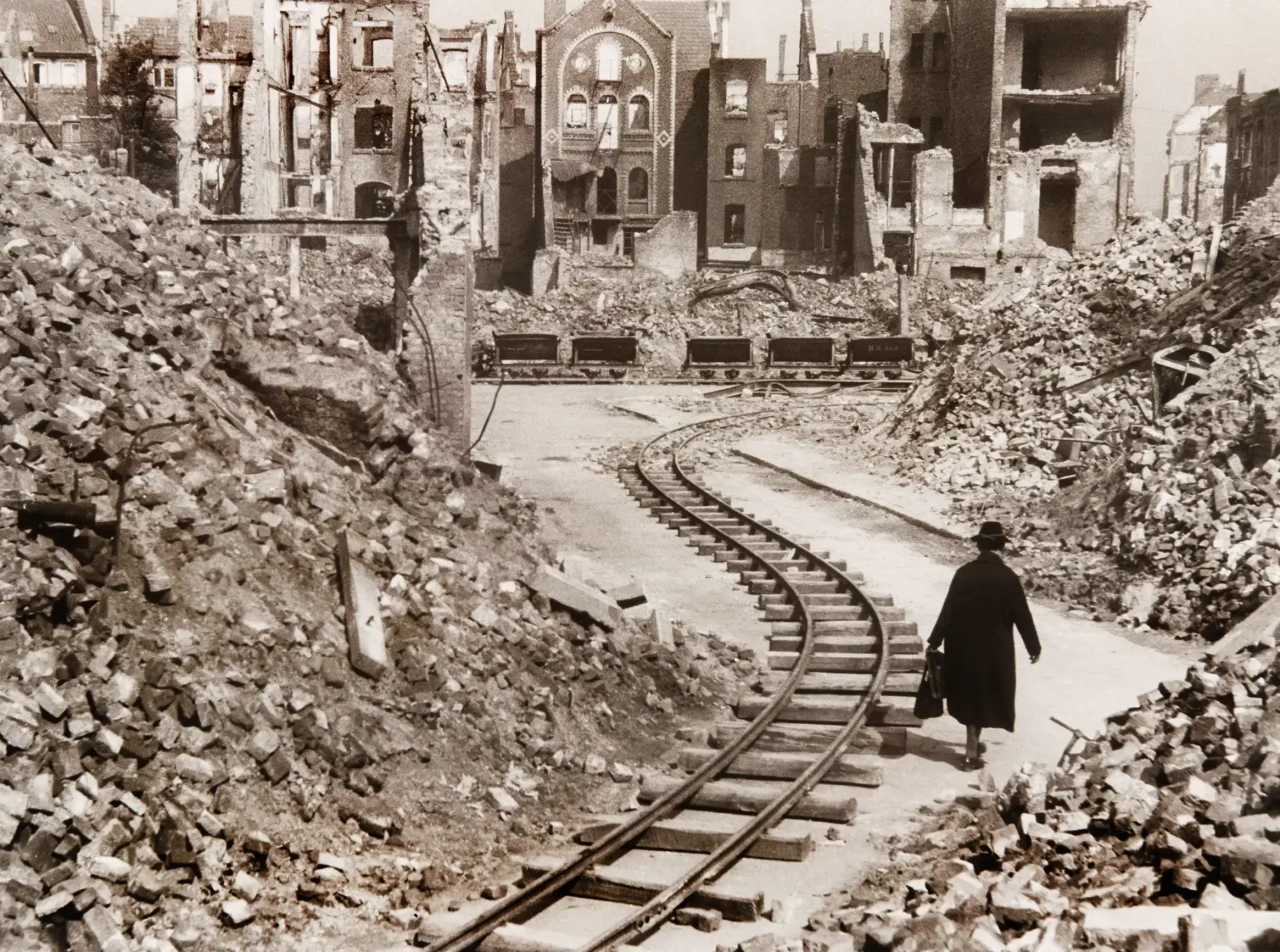 Schienen verlaufen zwischen Trümmerbergen.