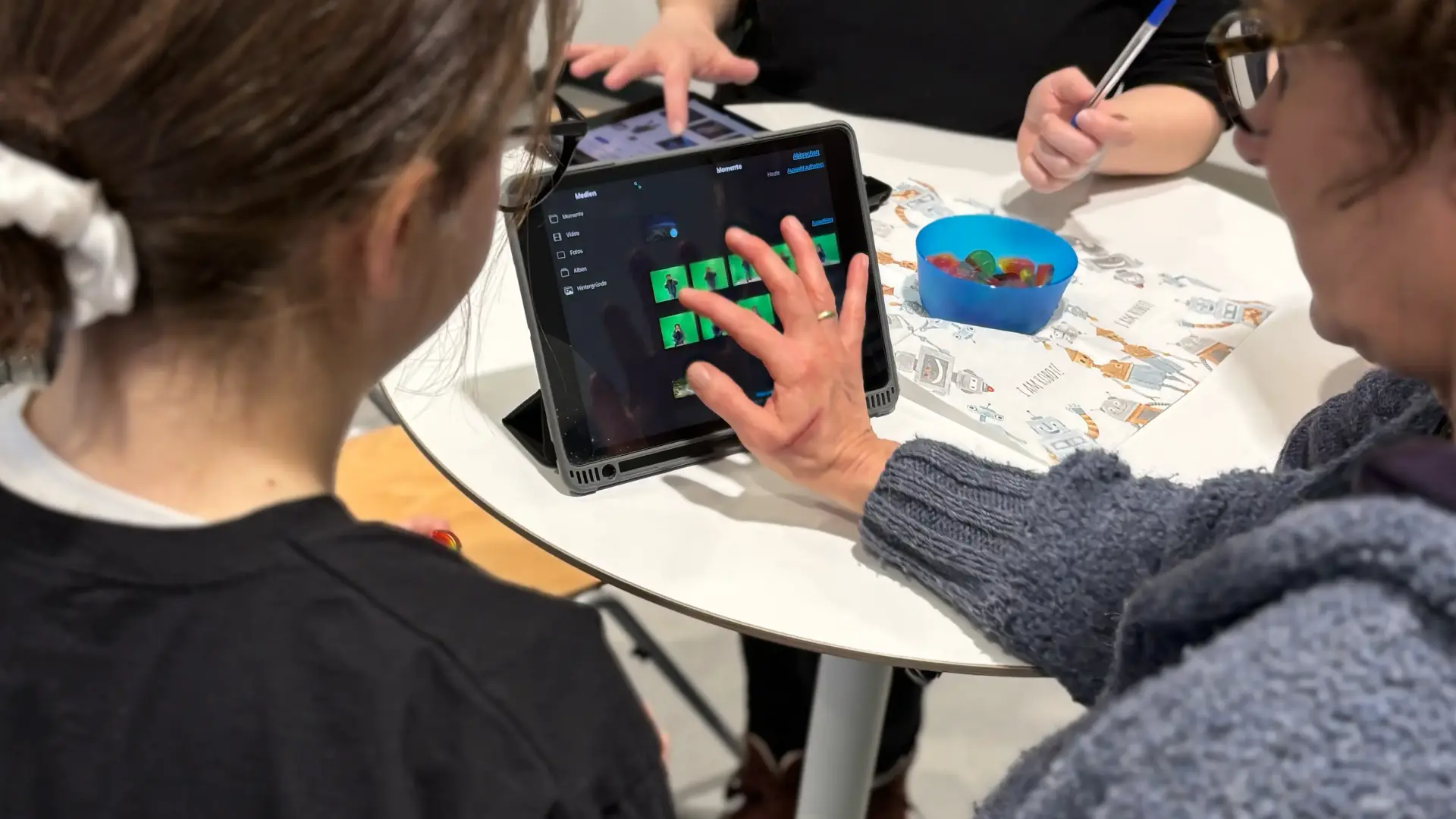 Schülerin erklärt Lehrkraft eine Green-Screen-App