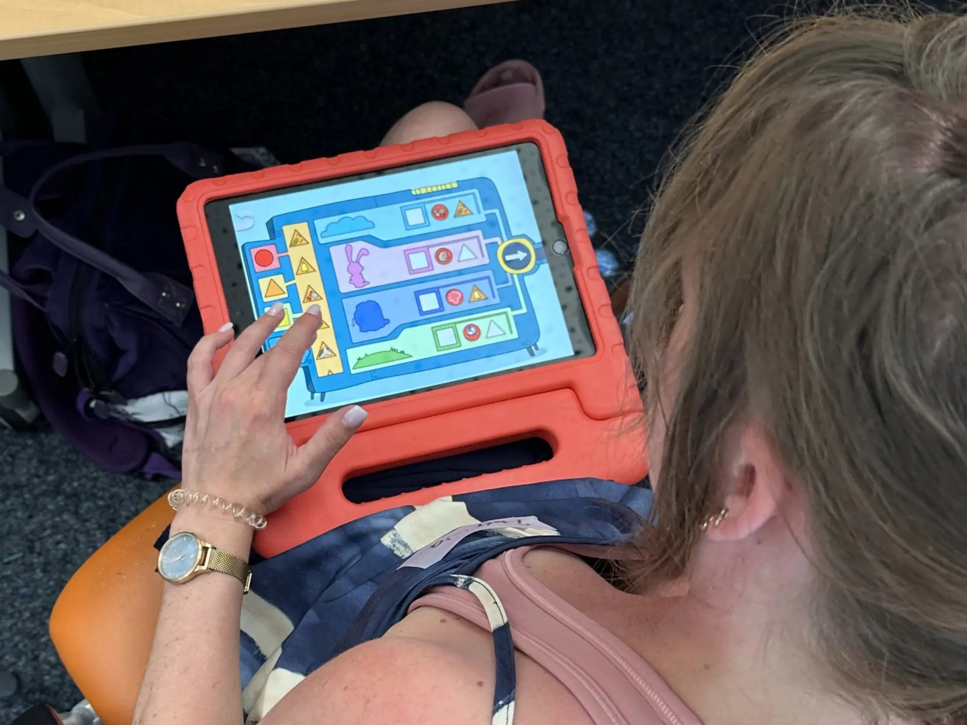 Person schaut auf Tablet, auf dem die Wenn-Dann-Maschine läuft