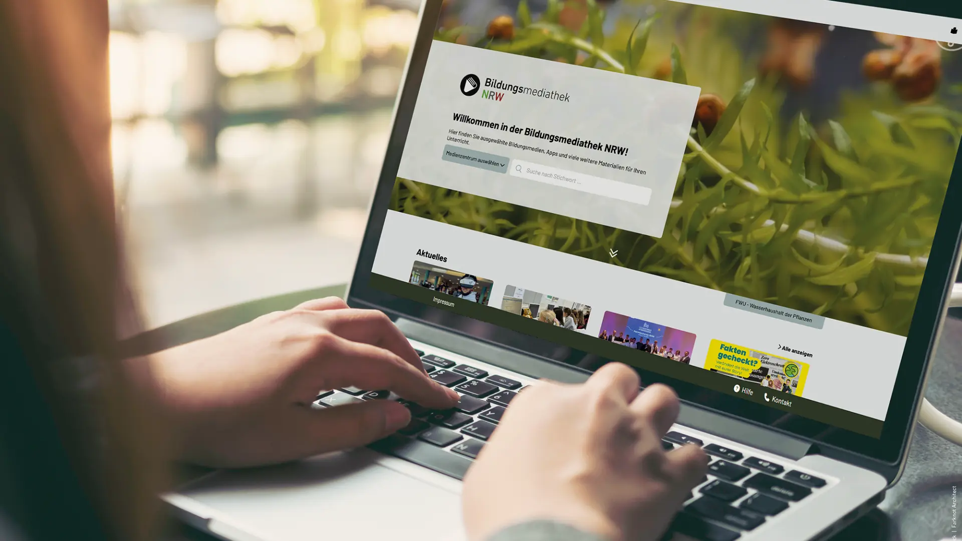 Ansicht Bildungsmediathek Startseie auf Laptop, Hände an Tastatur