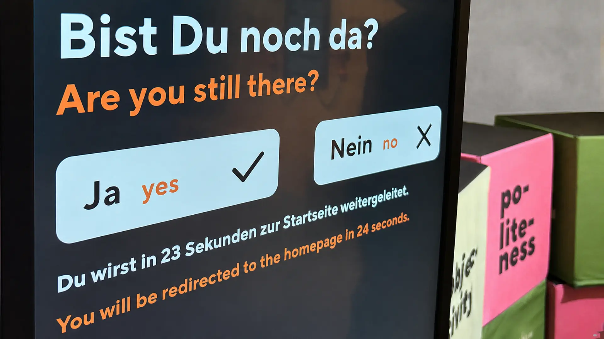 Ein Monitor in einer Ausstellung, auf dem eine Frage an den Betrachter erscheint