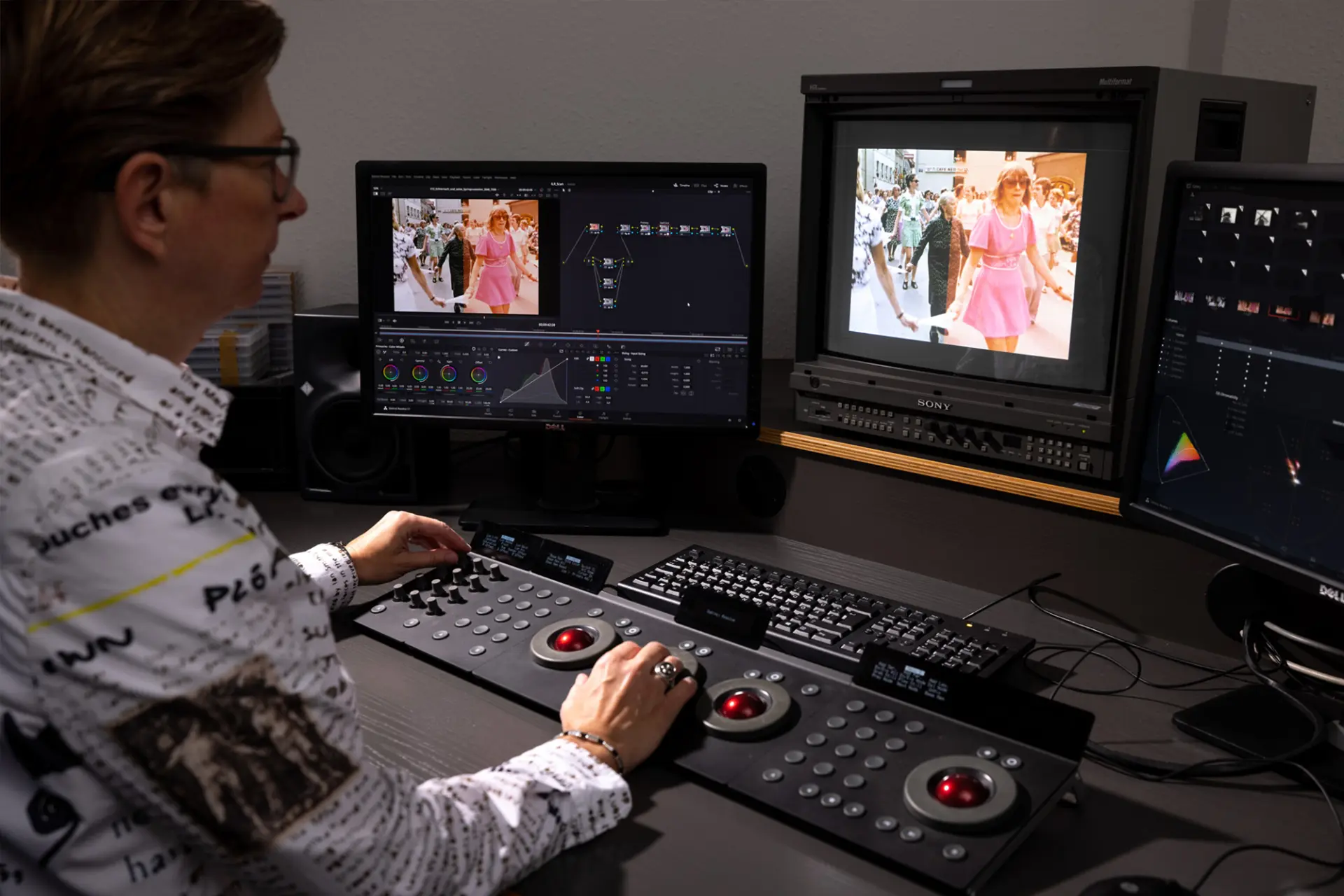 Person arbeitet an einer Farbkorrektur-Station mit Monitoren für digitales Colorgrading von Filmmaterial.