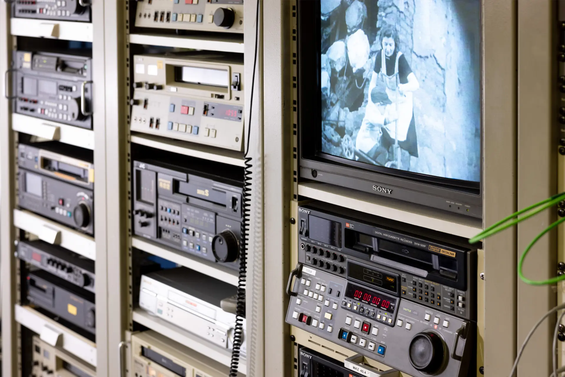 Nahaufnahme von Videorekordern und Monitoren in einem Studio zur Film- und Videodigitalisierung.