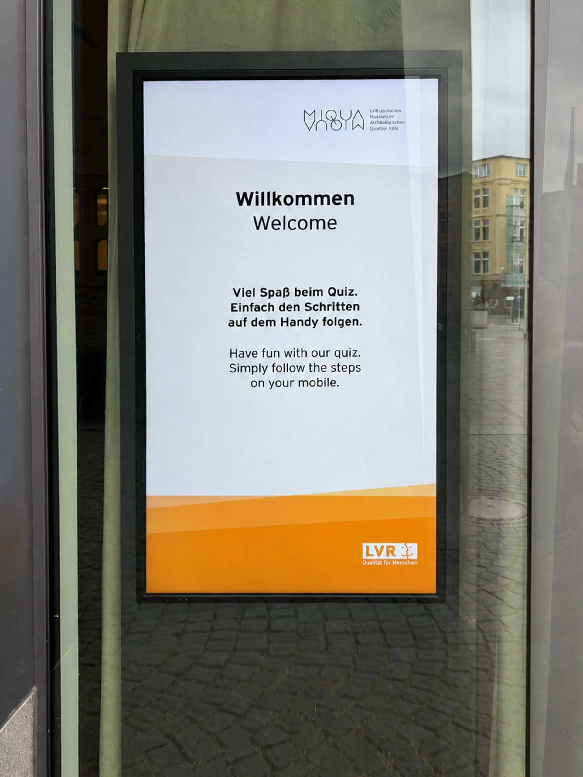 Digitale Stele mit Willkommensbildschirm und Hinweisen zur Nutzung des Quiz auf dem Smartphone