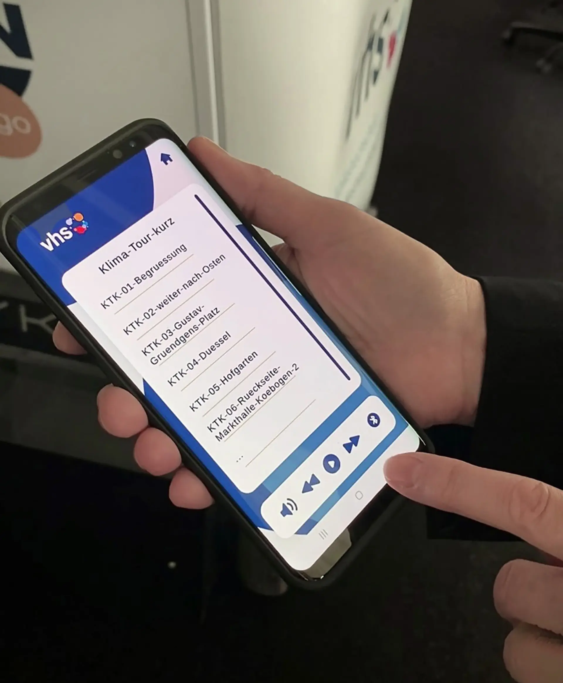 Person bedient auf einem Smartphone die App einer inklusiven Klima-Tour der Volkshochschule Düsseldorf.